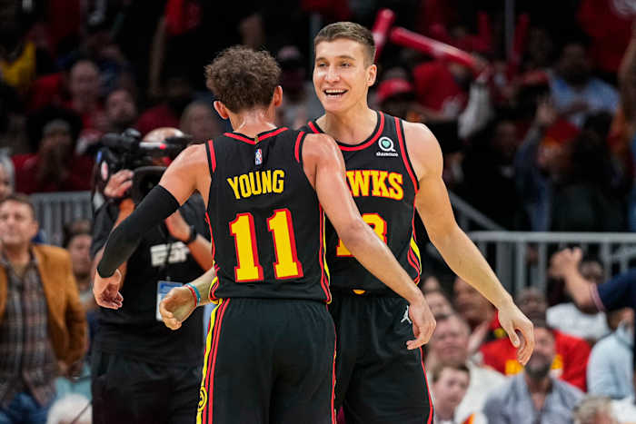 Apr 13, 2022; Atlanta, Georgia, USA; Atlanta Hawks guard Trae Young (11) reacts with guard Bogdan Bogdanovic (13) after a basket against the Charlotte Hornets during the second half at State Farm Arena.